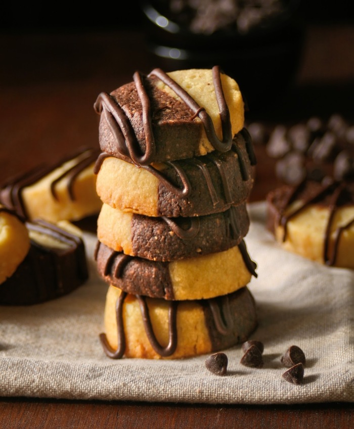 A stack of almond butter cookies drizzled with chocolate.