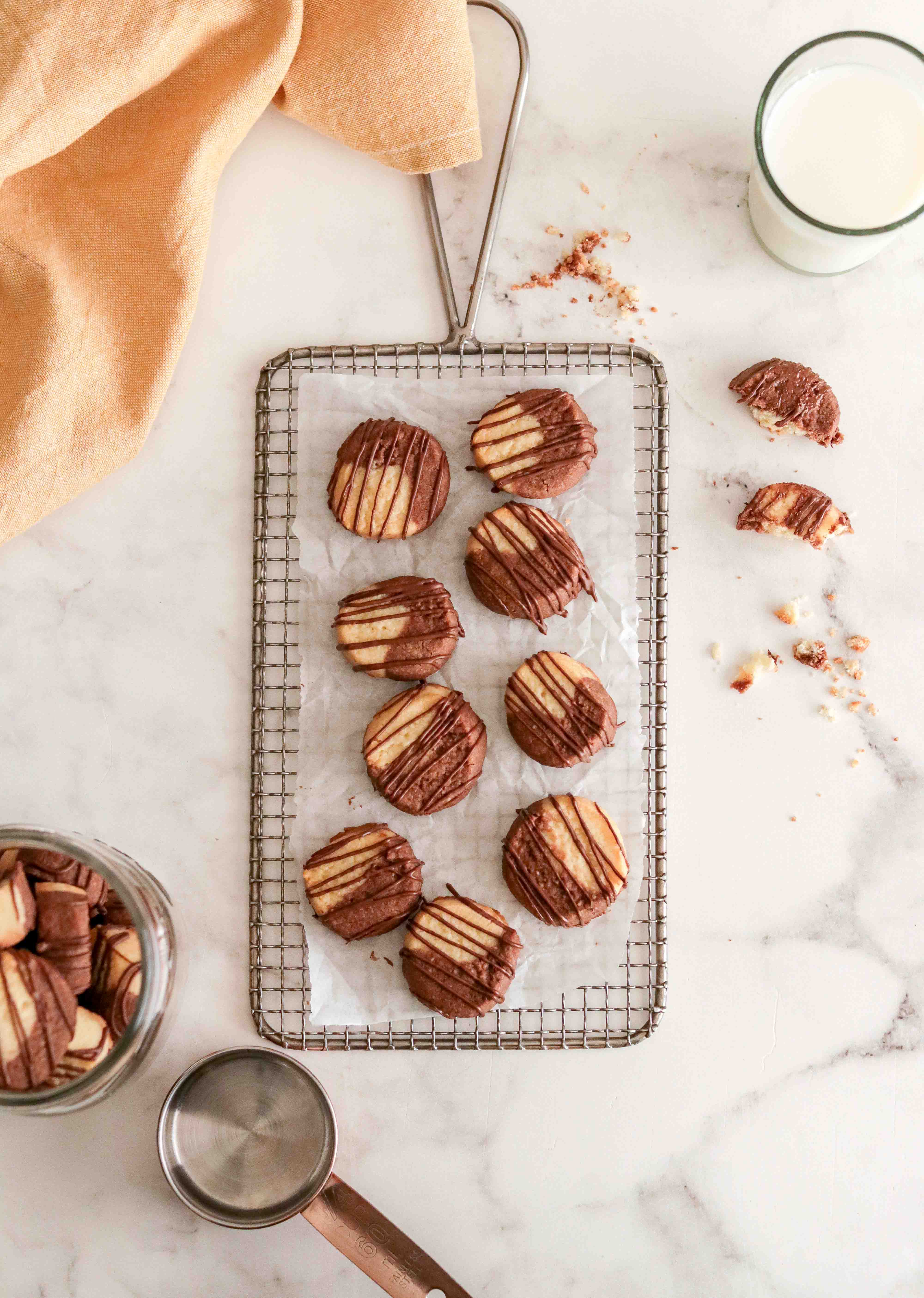 Top shot of chocolate cookies on a cooling rack with a glass of milk 