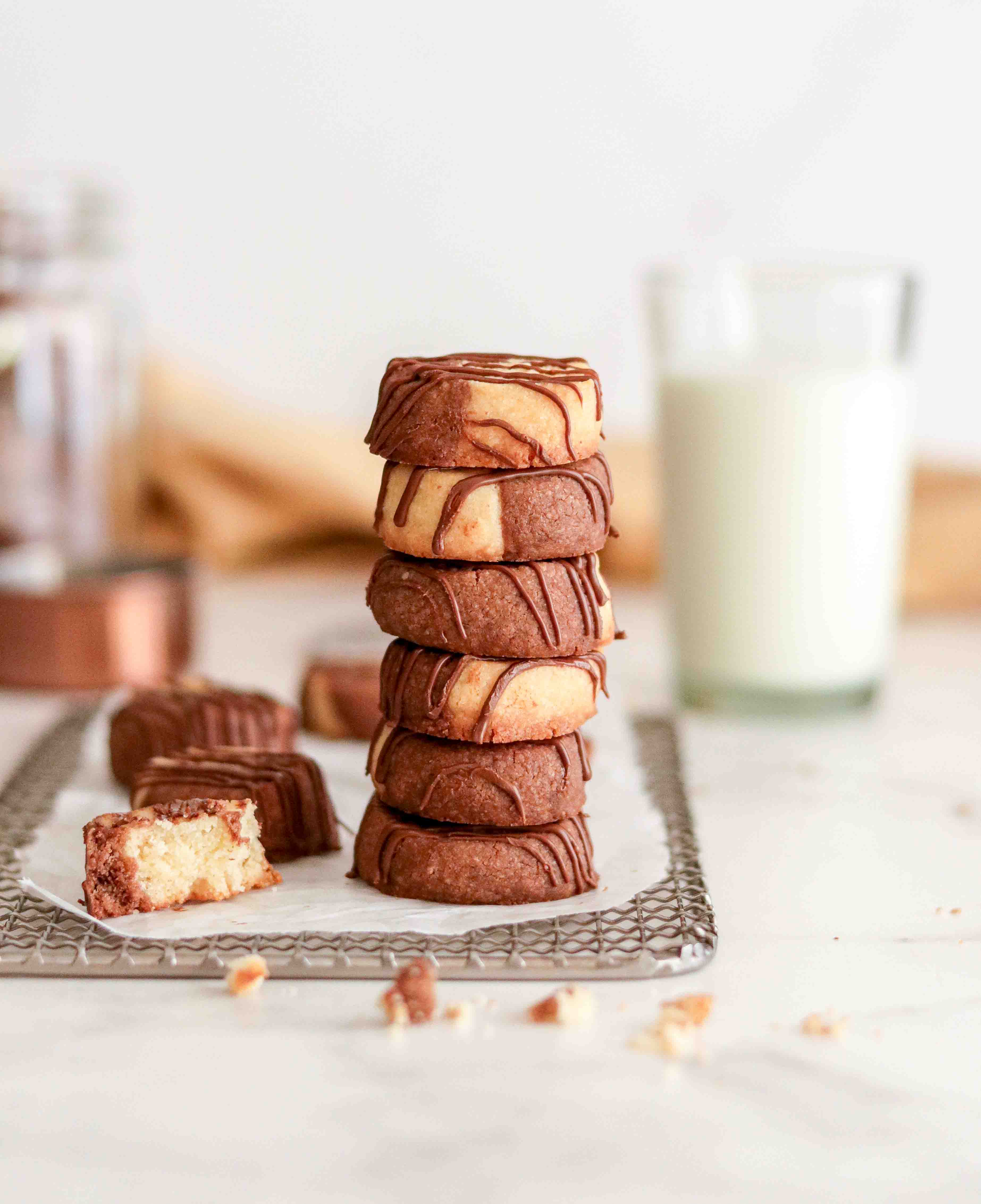 A tower of butter cookies with milk in the background 