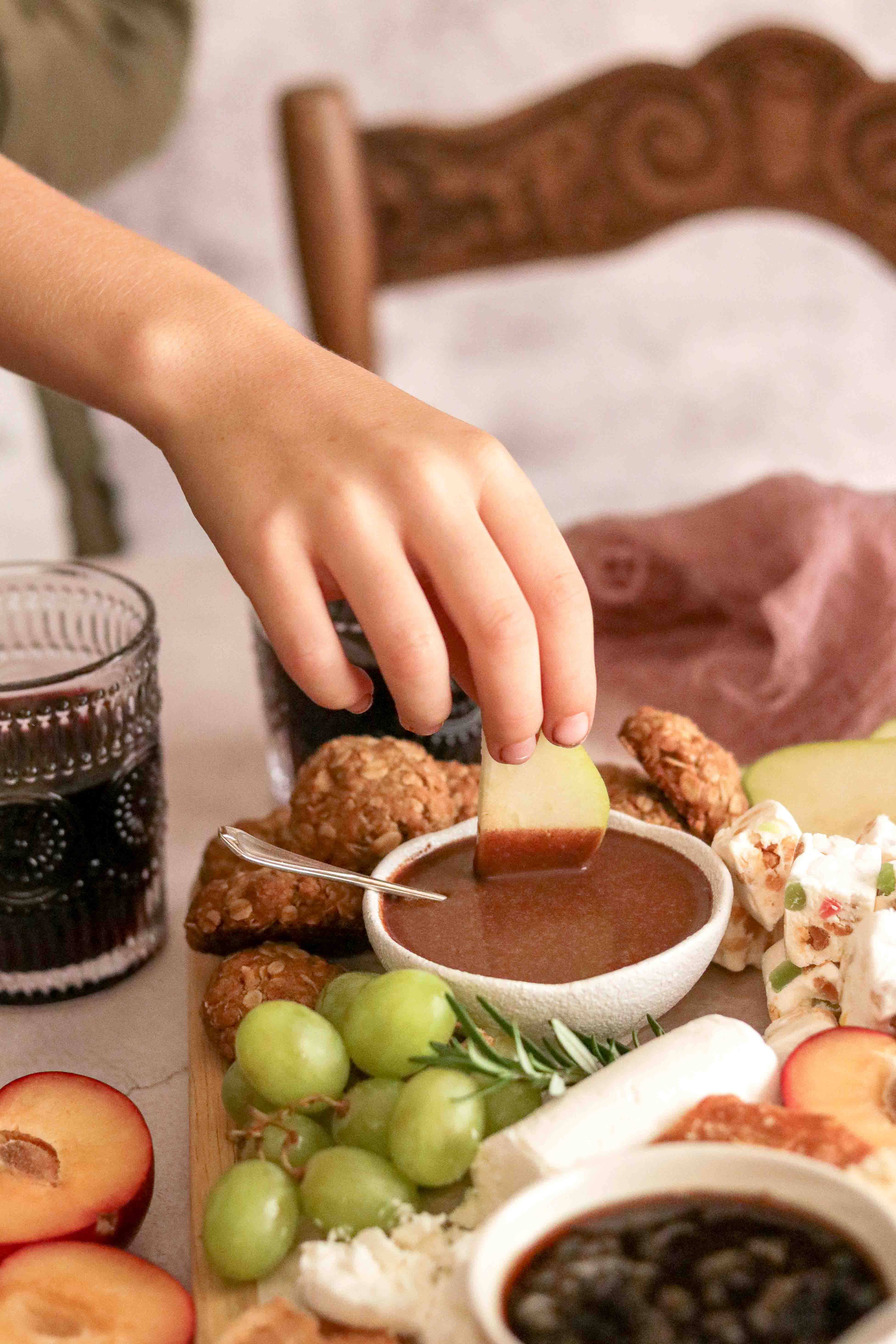 Photo of an apple being dipped into ganache
