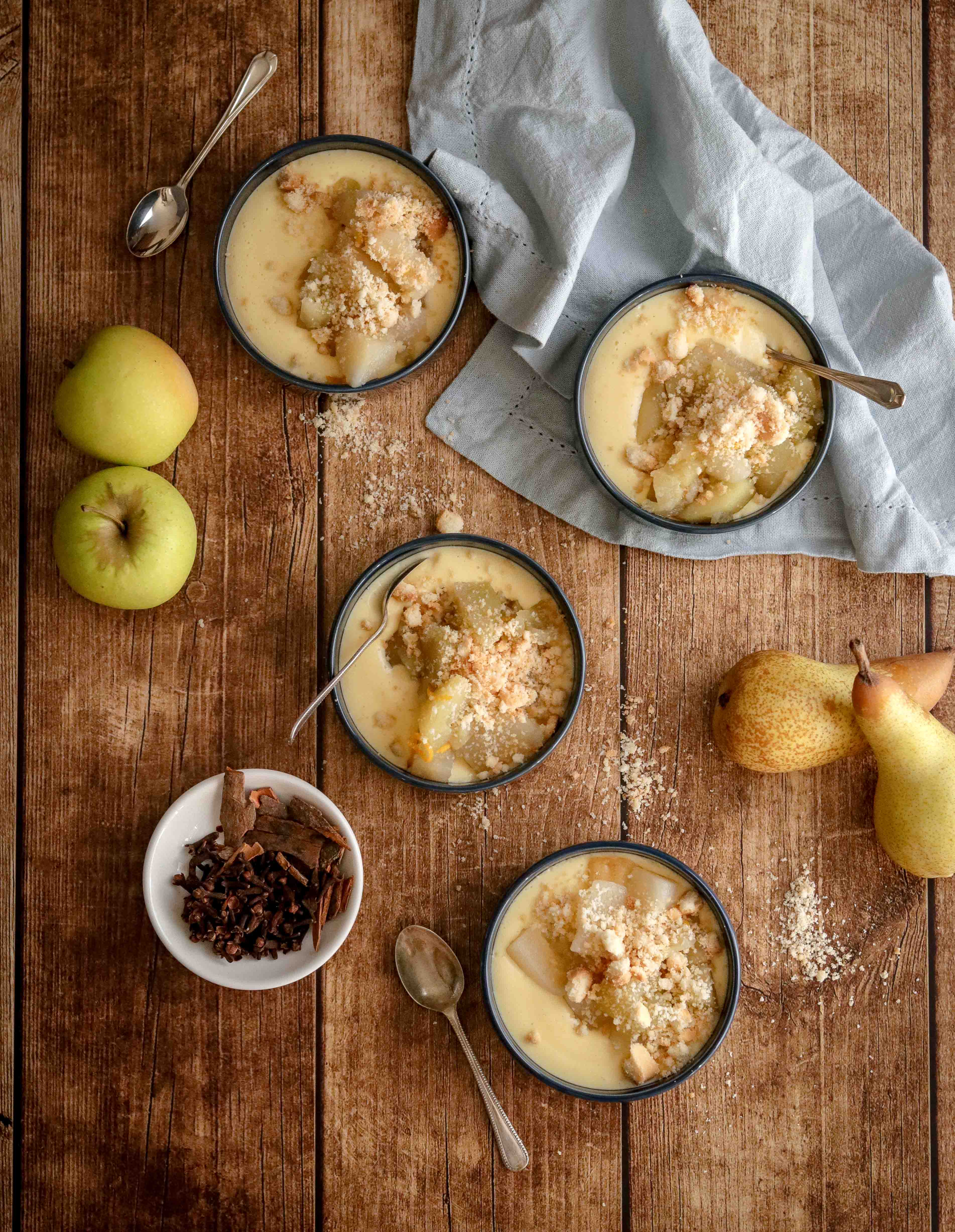 Bowls of homemade custard topped with spiced fruit and crumble