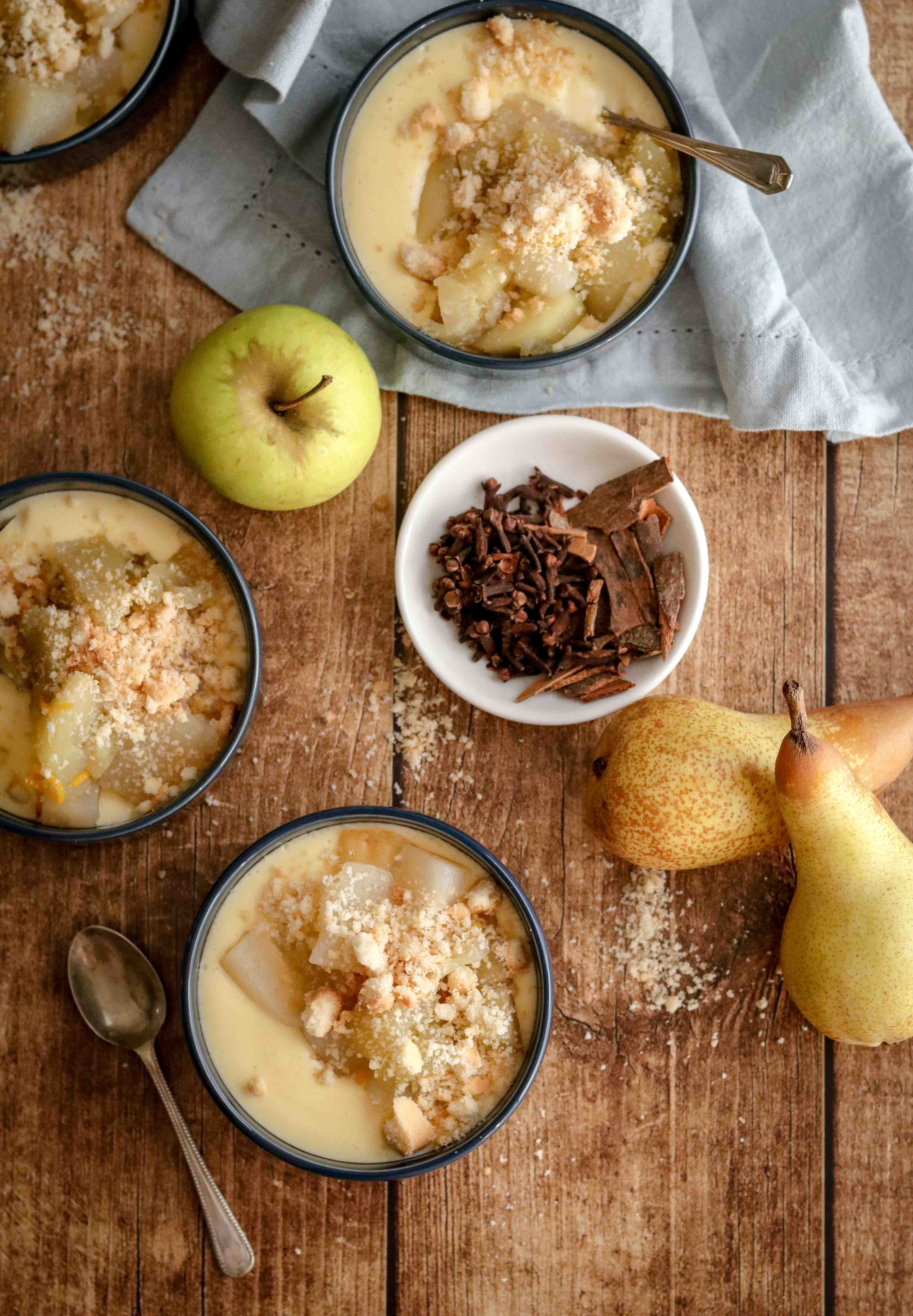 Bowls of homemade custard topped with spiced fruit and crumble