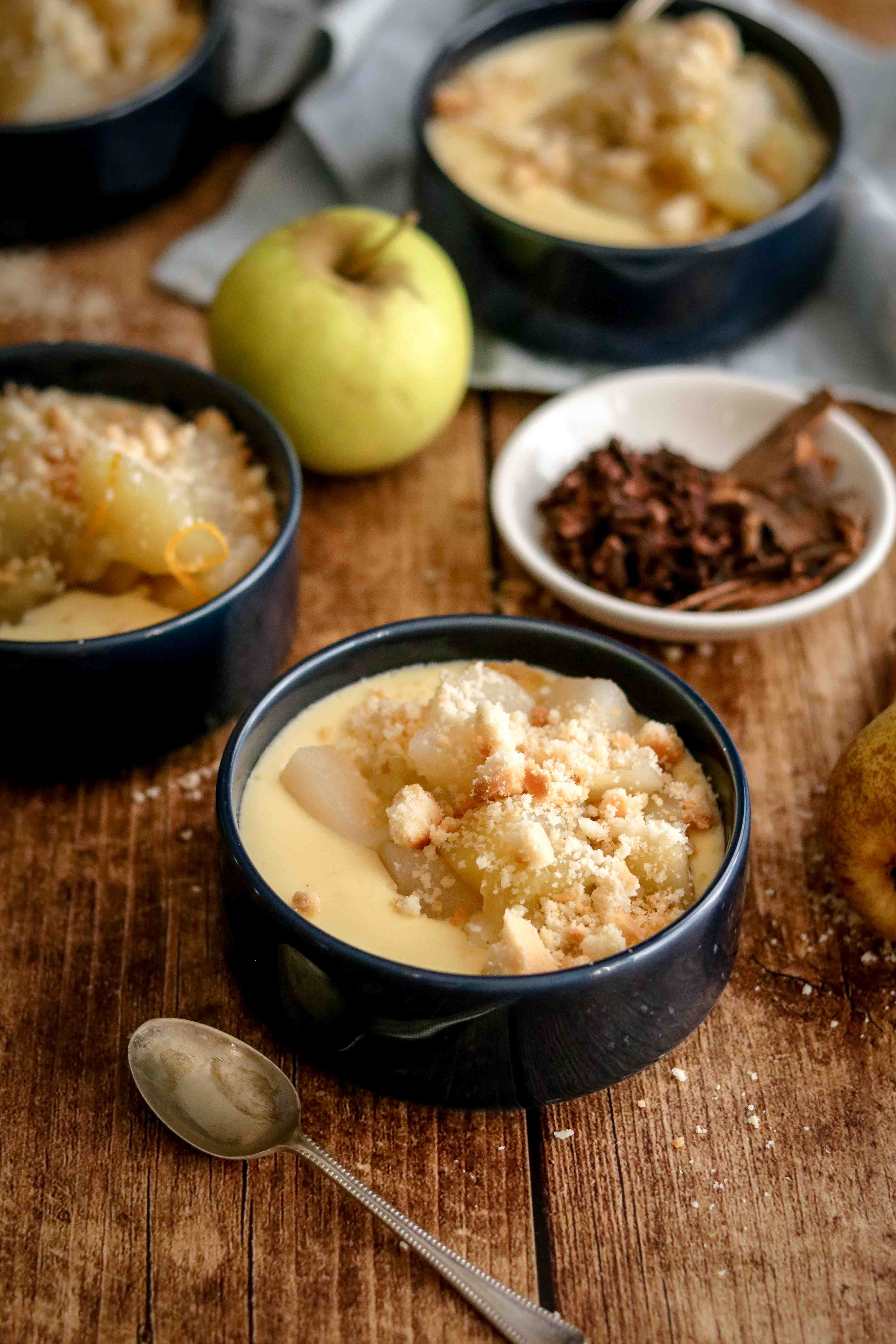 Bowls of homemade custard topped with spiced fruit and crumble