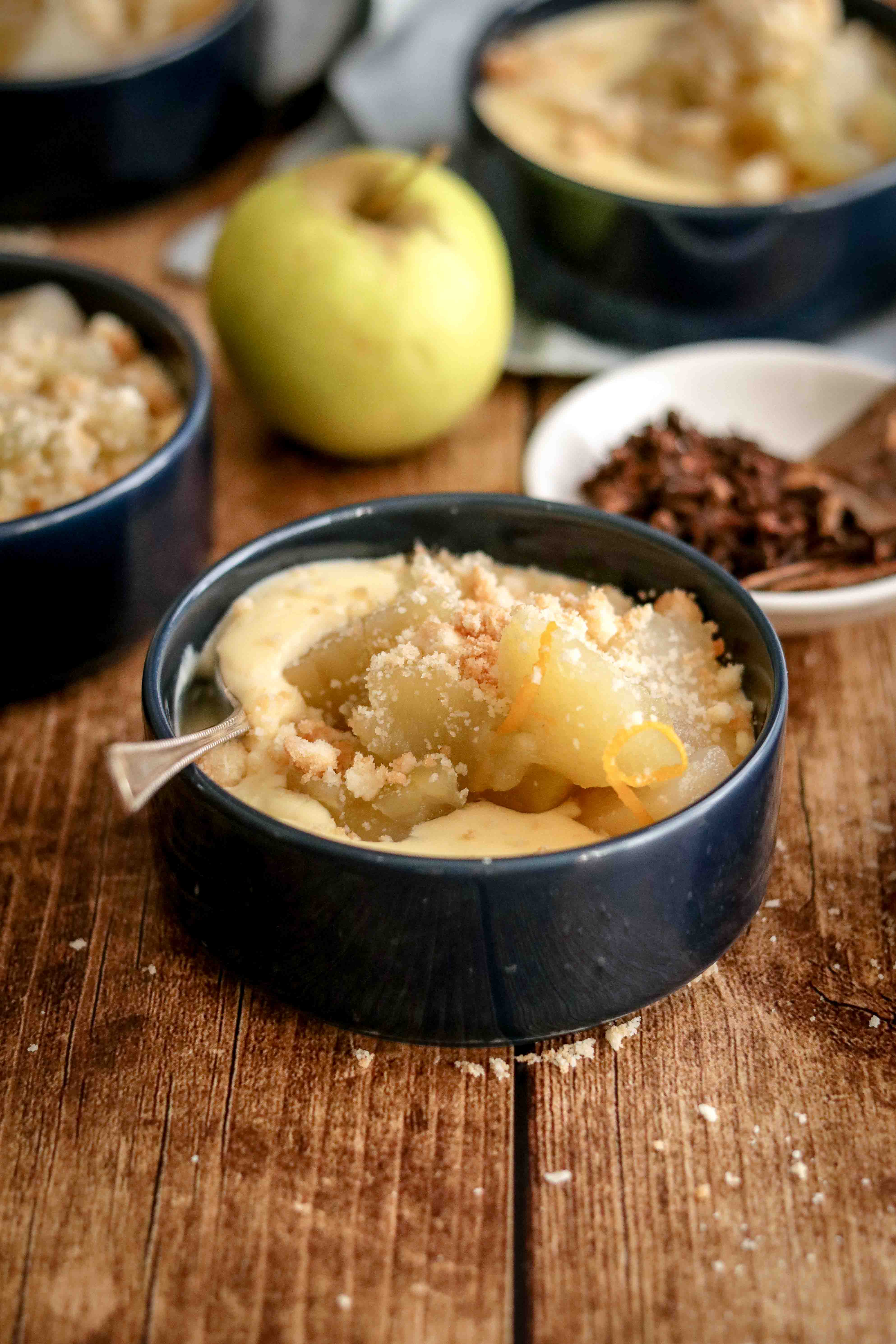 Bowls of homemade custard topped with spiced fruit and crumble