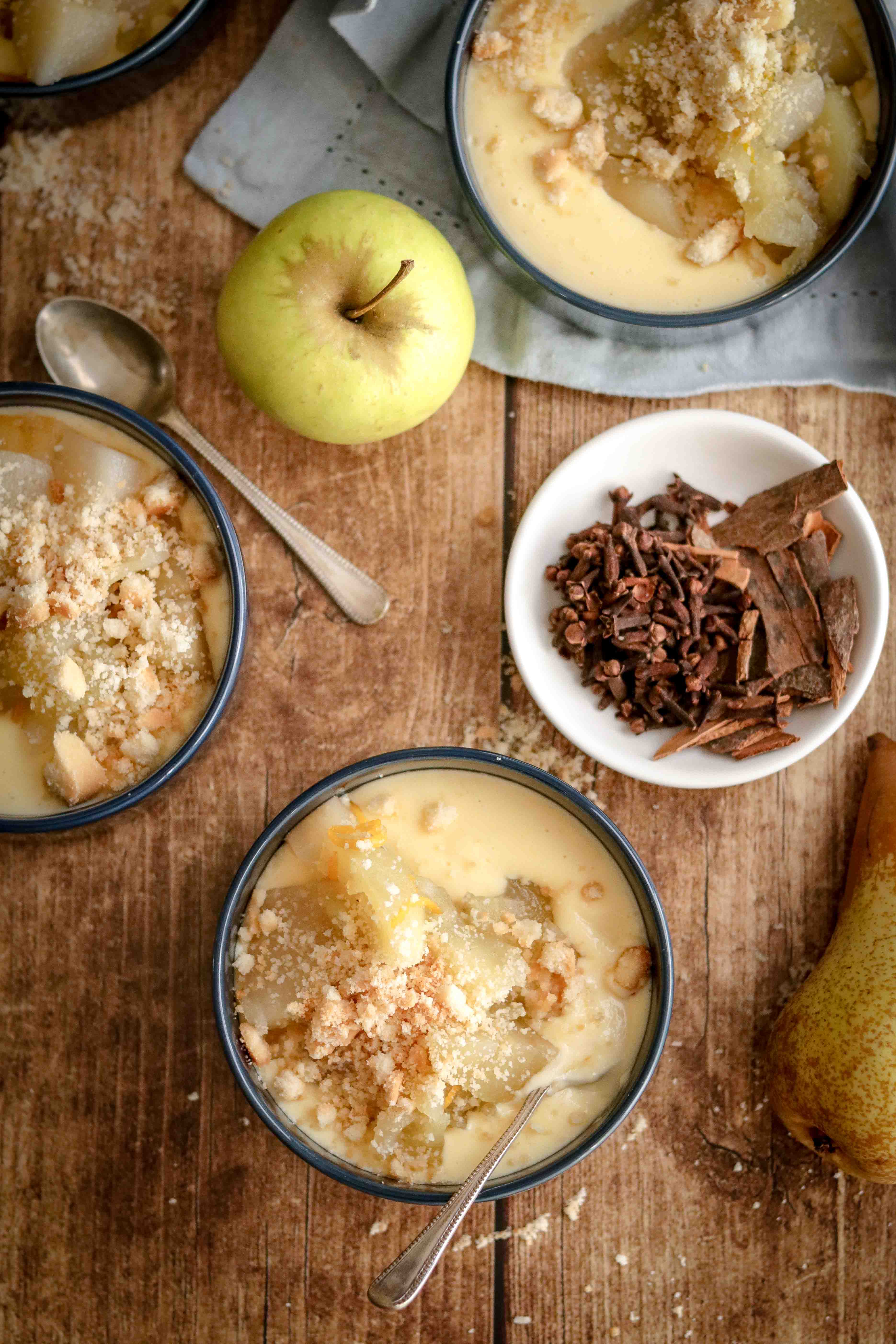 Bowls of homemade custard topped with spiced fruit and crumble