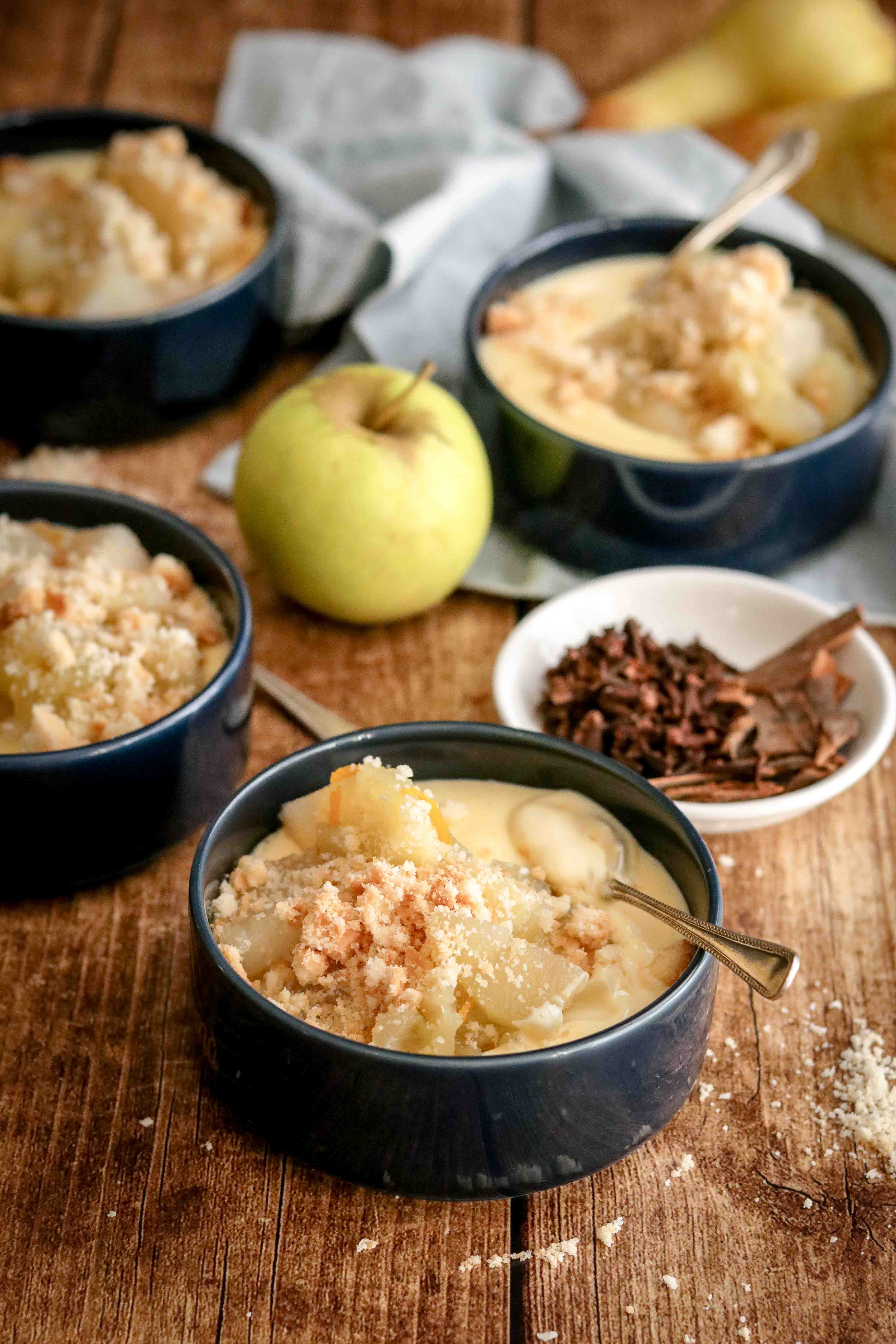 Bowls of homemade custard topped with spiced fruit and crumble