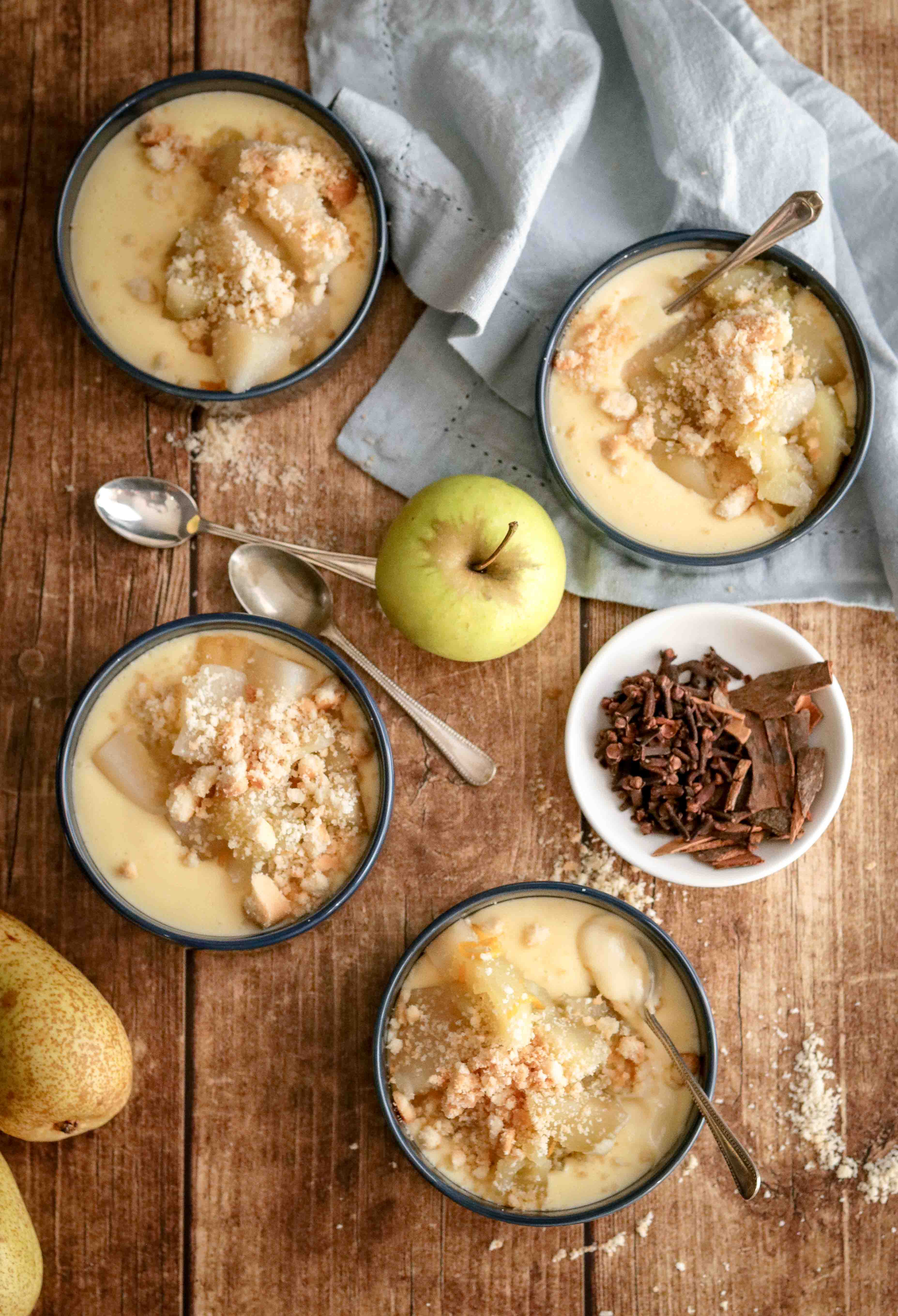 Bowls of homemade custard topped with spiced fruit and crumble